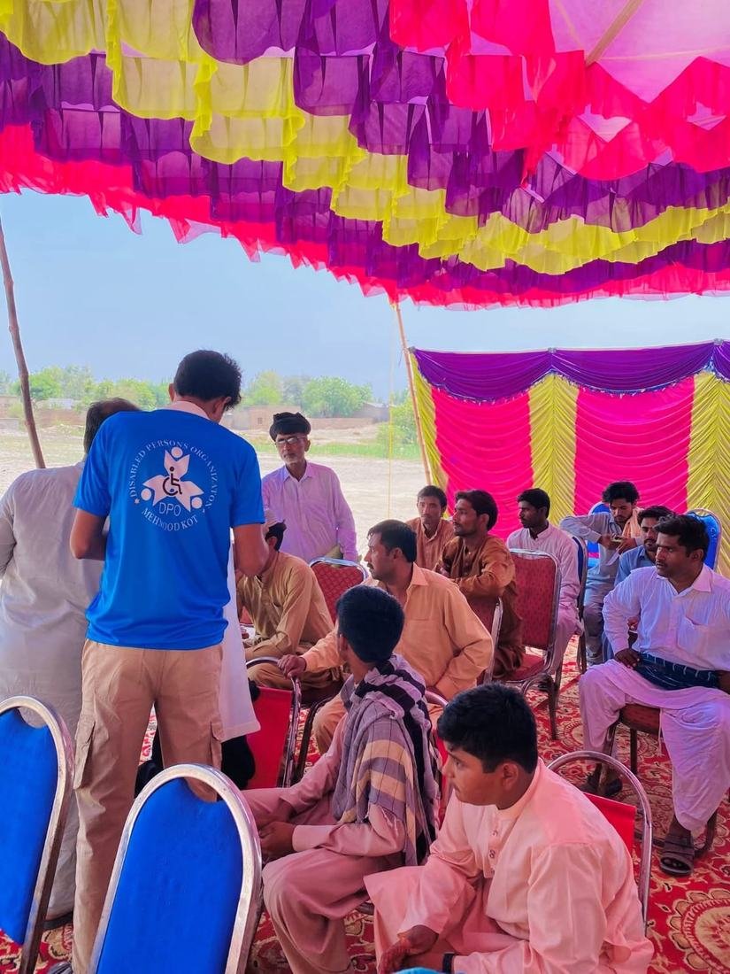 DPO volunteer speaking with community members about a new water project